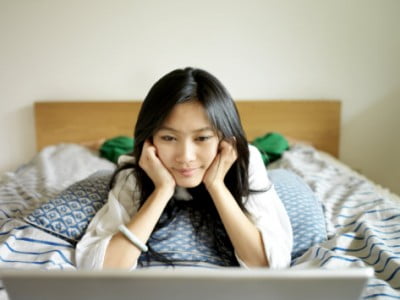 eightfish-young-chinese-woman-watches-a-movie-on-her-laptop-sprawled-on-a-bed_i-G-40-4041-469LF00Z1